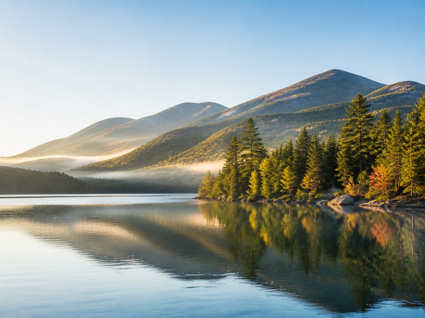 A peaceful New Hampshire lake surrounded by forested mountains